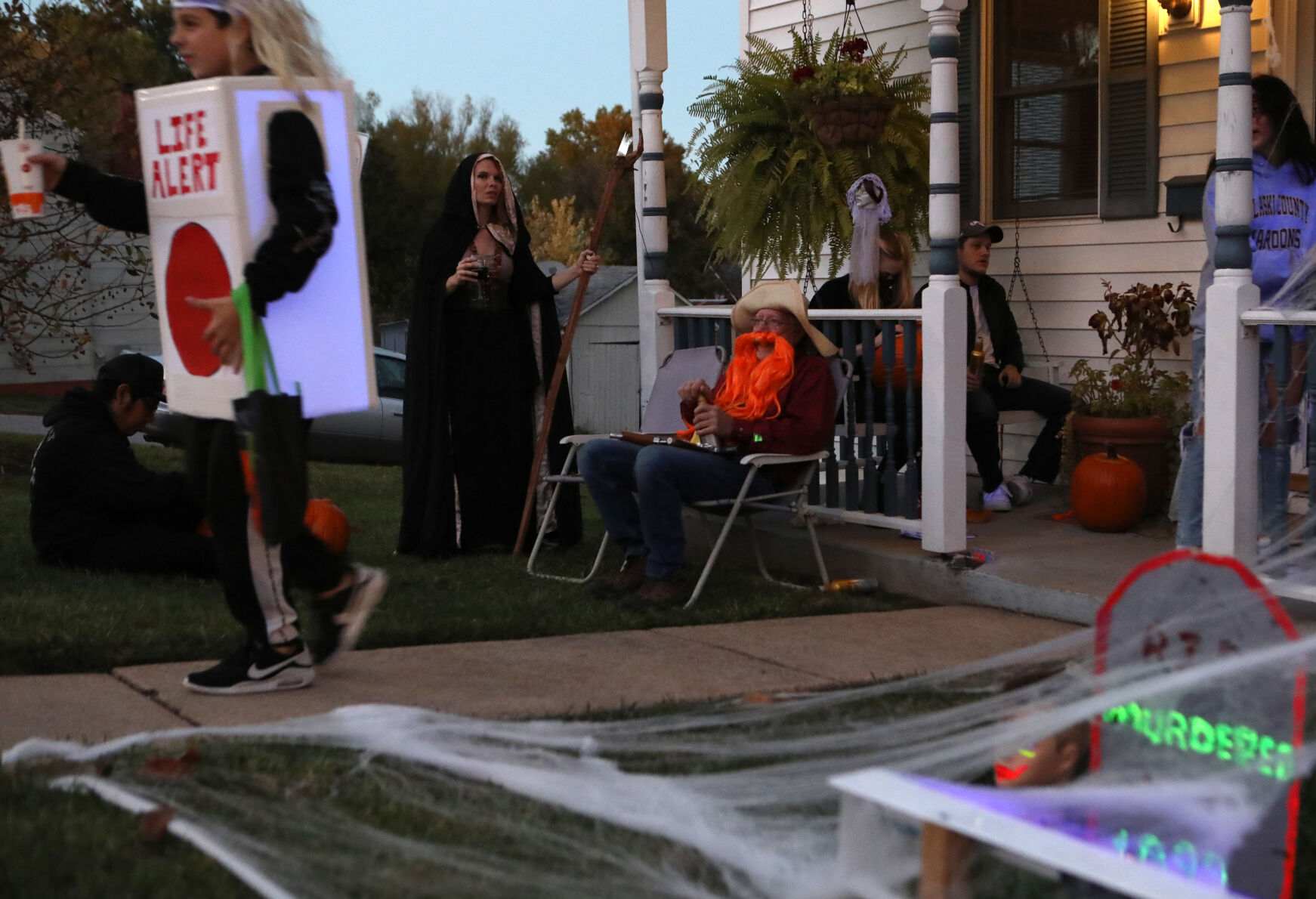 Jim Haberberger sits as children trick or treat